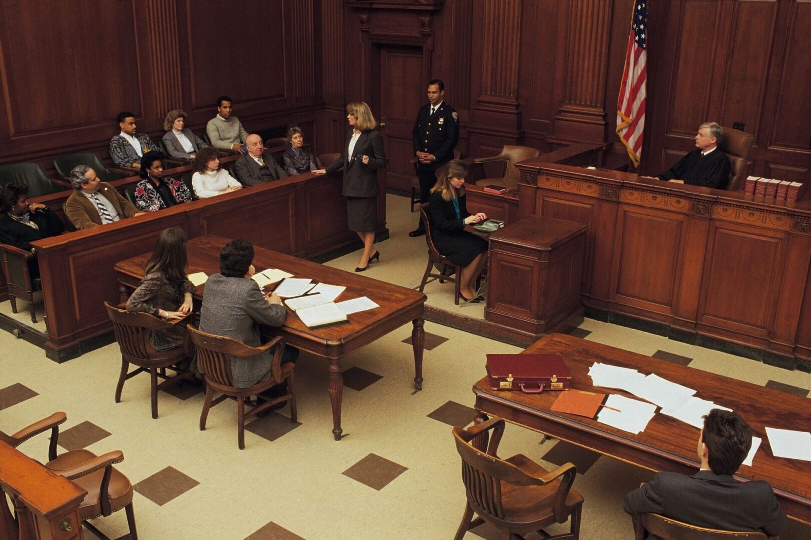 A courtroom with judges and defendants in the foreground.
